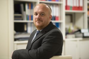 Portrait of Jude Hodgson in his office, looking at camera
